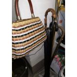 An ebony walking stick; 2 others; a cane handled umbrella; a 60's handbag