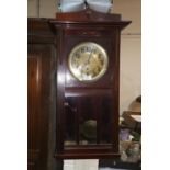 A mahogany cased wall clock with brass dial and bevelled glass