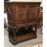 A 19th century oak Gothic style side cabinet with canted front, twin tracery work doors, drawer