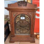 An Edwardian oak mantel clock with brass dial and chiming movement