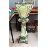 A Art Nouveau majolica jardiniere on stand, rim and feet restored