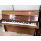 A neat modern sapele cased iron framed over strung piano by Heinz Kuhn, with duet stool