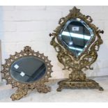 A 19th century brass easel mirror with mask, angel and cherub supports, on ornate rectangular footed