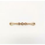 A yellow metal bar brooch, flared and pierced, set 3 diamonds, 5 gm