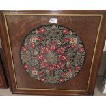 An embroidered circular panel with floral motifs, diameter 38 cm, framed; a circular embroidery of a