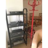 A modern black metal 4 height shelf unit and similar uplight; a red hat and coat stand