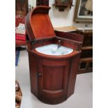 A Victorian pitch pine case corner unit fitted with a ceramic washbasin, hinged lid and door, in the