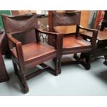 A pair of Arts and Crafts oak armchairs with leather upholstery and embossed lines