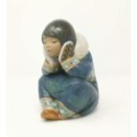 A Lladro figure of an Inuit girl sitting resting head on hands
