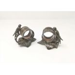 Two silver plated napkin rings decorated with birds stood on leaves; a small hip flask and 4 salt