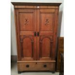 An early 20th century oak wardrobe enclosed by 2 doors with marquetry inlay and arched panelling,