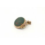 An Edwardian swivel fob in 9 carat mount, set green and red polished stoes,15 gm gross