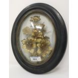 A 19th century gilt work floral trophy under domed oval glass, ebonised frame, 29 x 23 cm overall