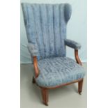 A 130s high wing back armchair in blue brocade on square tapering legs and castors