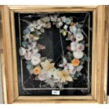 An ornate floral wreath in coloured feathers and waxed paper, gilt cabinet frame, 57 x 51 cm overall
