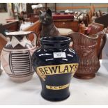 A blue advertising vase for Belway's B.S. No 1, in black and gold text, two jugs, and a cat
