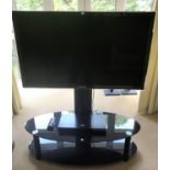 A large 45" Samsung flatscreen TV on black glass stand