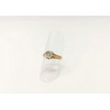 A yellow and white metal solitaire ring with diamond in hexagonal setting, relief decoration to