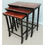 A nest of red lacquered occasional table with rectangular tops