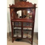 An Art Nouveau inlaid mahogany display cabinet with mirror back, open shelf with side spindles