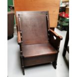An early 19th century oak monks chair