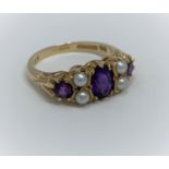 A 9ct dress ring with three amethyst coloured stones and four seed pearls