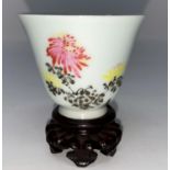 A Chinese porcelain small cup decorated with flowers and characters, on stand, ht 5.5cm