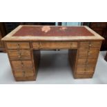 A 1930's oak kneehole desk with inset leather top (a.f.), 7 drawers with brass teardrop handles,