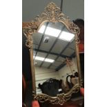 A wall mirror in ornate gilt frame