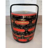 A 20th century Chinese picnic set, 3 height and circular in black and red lacquer