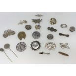 A selection of Victorian and later white metal brooches with embossed and chased decoration
