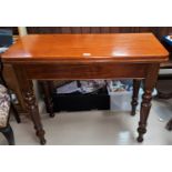A 19th century mahogany tea table with fold-over top, on turned legs