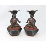 A pair of unusual Chinese pewter candle sticks in the form of characters sat on box with space for