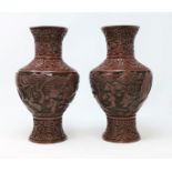 A pair of Chinese cinnabar vases with traditional scenes height 23cm (some areas of damage)