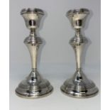 A pair of silver candlesticks with turned decoration (weighted)