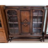 A 1930's oak display cabinet with 2 glazed and panelled doors