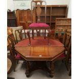 A reproduction walnut dining table with octagonal top, and a set of walnut dining chairs in the