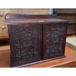 An Edwardian stained mahogany small double cupboard with Macclesfield style carving to the doors,