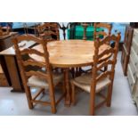 A modern pine dining suite comprising circular table and 4 ladder back rush seat chairs