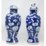 Two Chinese blue and white prunis blossom lidded baluster vases (some restoration) height 39cm