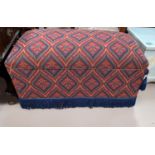 An ottoman in red pattern tapestry upholstery