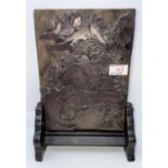 A Chinese ink stone panel on stand carved with traditional scene to one side and text to the