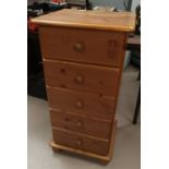 A pine 5 height narrow chest of drawers; a glass occasional table/magazine rack