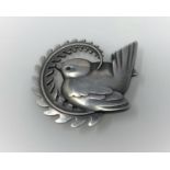 A Georg Jensen silver brooch, wren perched on fern frond, name impressed in beaded circle, stamped