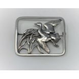 A Georg Jensen silver brooch, pierced rounded rectangular shape, a duck flying past bulrushes,