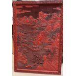 A very large Chinese cinnabar coloured wall hanging showing traditional mountain scene 114cm x 77cm