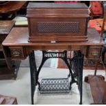An early 20th century Singer cast iron treadle sewing machine with mahogany cover and top