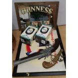 A Guinness advertising poster and small mirror, two boxed Guinness goblets etc