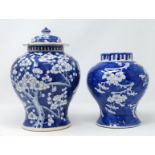 A Chinese blue and white lidded vase decorated with prunus blossom and another similar vase (no lid)