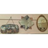 A gilt framed wall mirror, another peach surround mirror and another